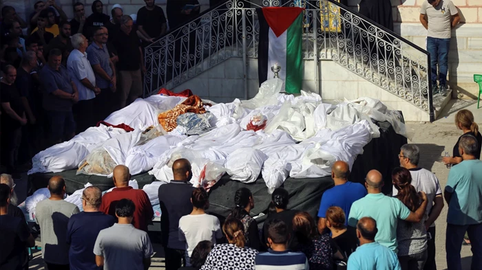 ألاقارب يحضرون جنازة المسيحيين في غزة الذين قُتلوا بعد غارة جوية إسرائيلية بالقرب من كنيسة القديس بورفيريوس الأرثوذكسية.