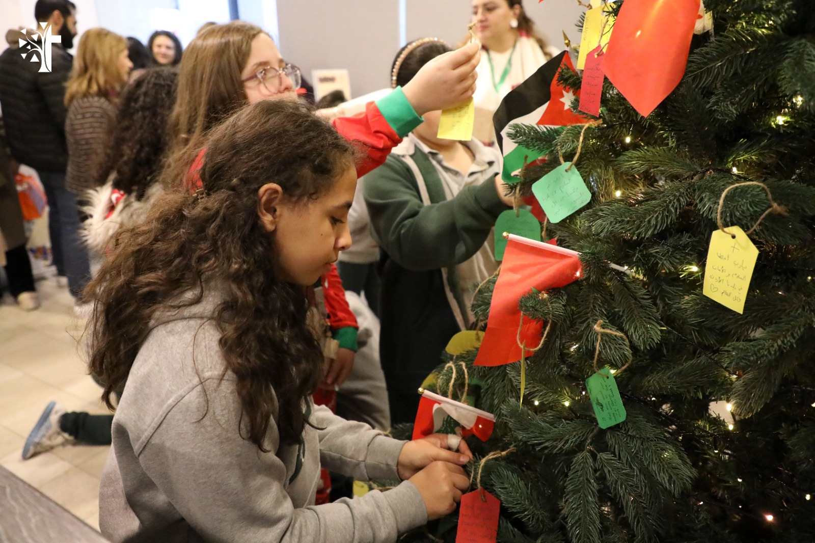 الطالبة بيرلا كرادشة وزملائها يزينون شجرة الامنيات
