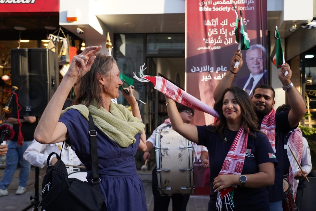 Foreign passersby joining Bible Society Staff in celebrating 79th Independence Day on Rainbow street.