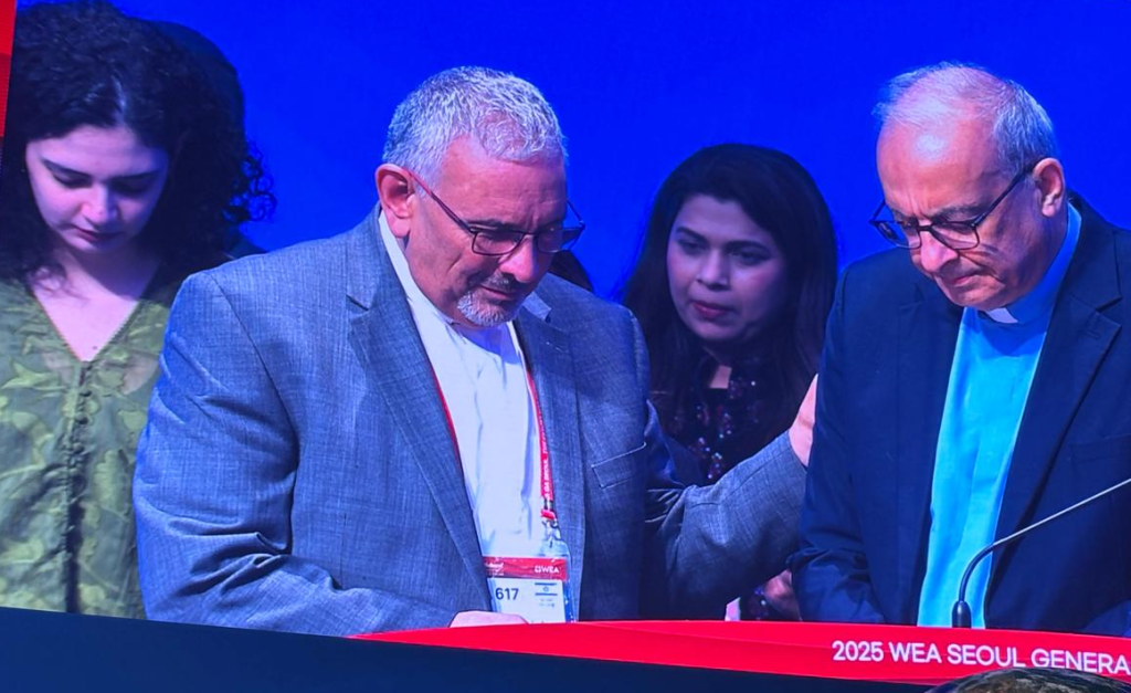 القس عازر عجاح يضع يده في صلاة للسكرتير العام الجديد للتحالف الإنجيلي العالمي القس بطرس منصور