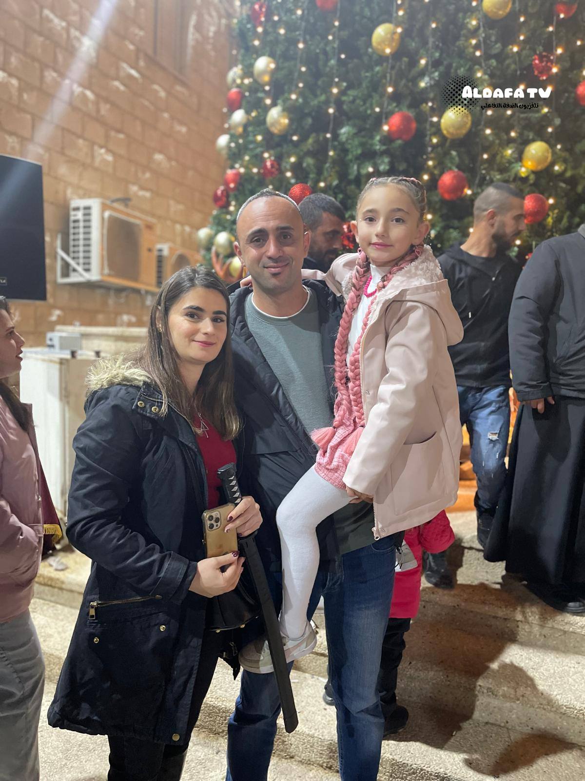 Palestinian Christian families in Jenin enjoying the relighting of the tree
